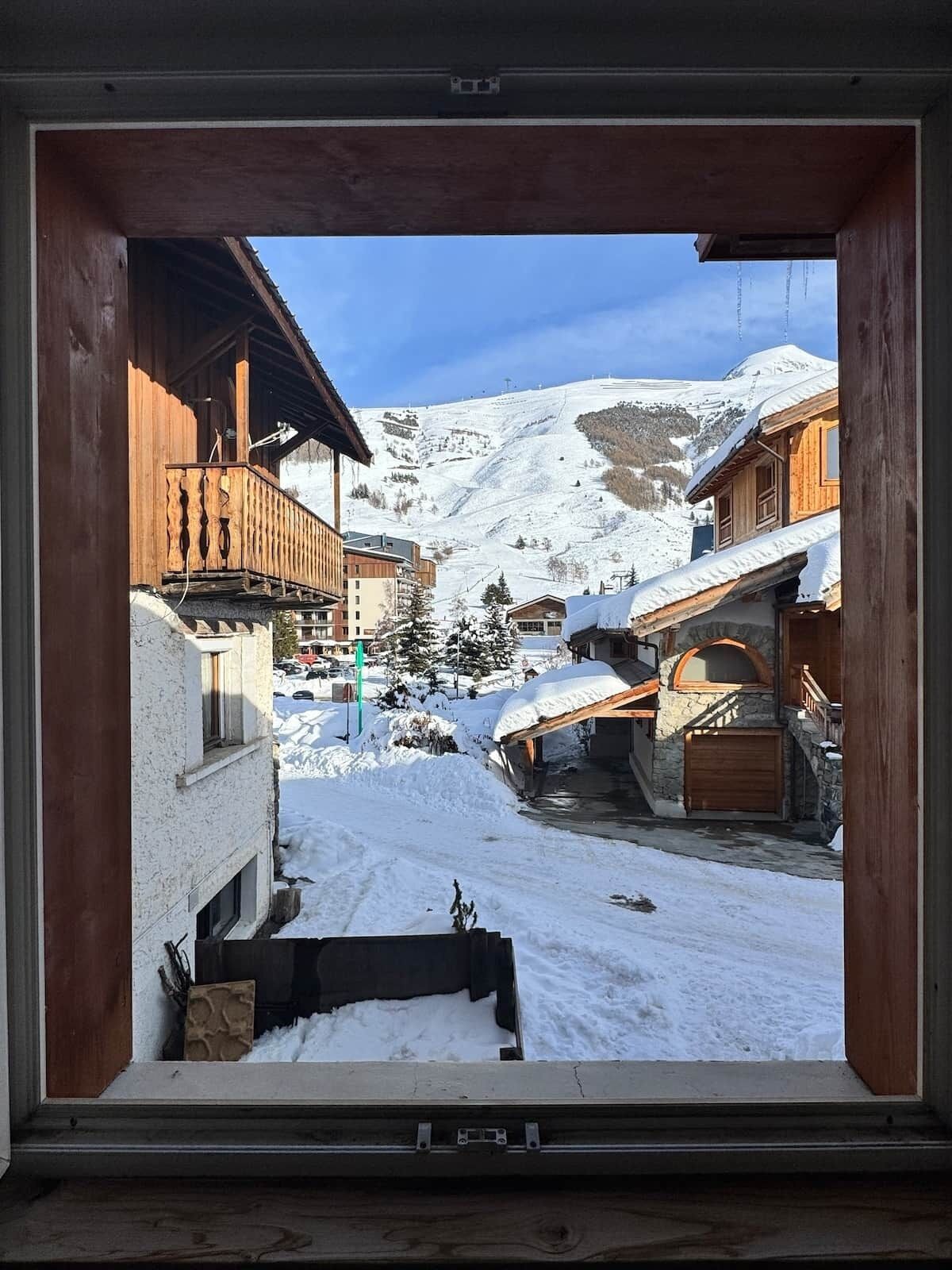 A snowy mountain village with wooden buildings and a clear sky.