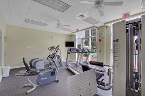 Ein Fitnessraum mit Laufbändern, Ergometer und einem an der Wand befestigten Fernseher.