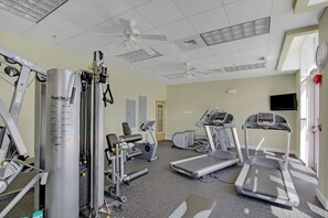 Ein Fitnessstudio mit Laufbändern, Crosstrainern und Gewichten.