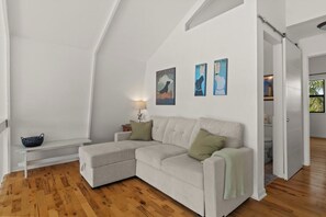 A modern living room with a sectional sofa, a small table, and wall art.