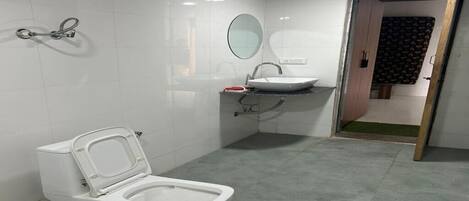 A bathroom with a toilet, sink, and mirror.