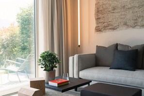 Ein stilvolles Wohnzimmer mit einer Couch, einem Couchtisch, einer Topfpflanze und einem Buch.