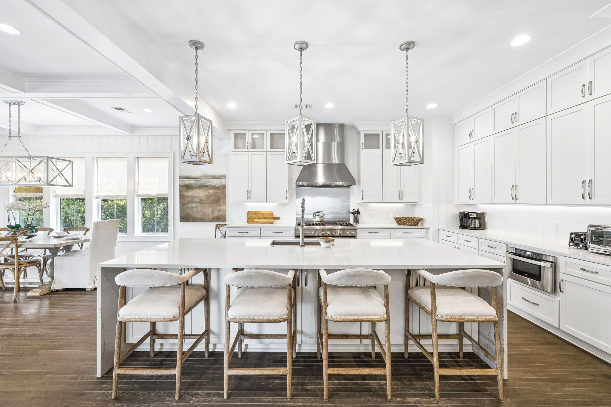 A modern kitchen with a central island, stainless steel appliances, and pendant lighting.