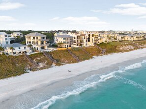 A coastal residential area with beachfront properties featuring balconies, a sandy beach, and ocean views. - Elegant Pet-Friendly Coastal Retreat with Private Pool, Cabana, & Elevator (Seacrest West)