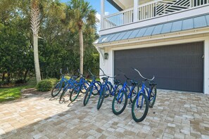 A row of bicycles parked in front of a building with a garage door. - Elegant Pet-Friendly Coastal Retreat with Private Pool, Cabana, & Elevator (Seacrest West)