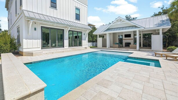 A modern two-story house with a swimming pool and outdoor seating area. - Elegant Pet-Friendly Coastal Retreat with Private Pool, Cabana, & Elevator (Seacrest West)