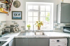 A kitchen with a sink, toaster, kettle, and a Bosch washing machine.