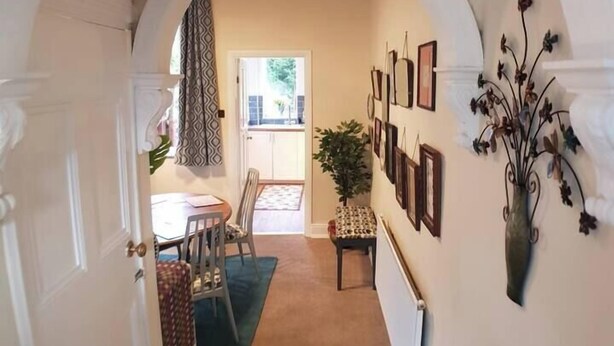 A hallway with an arched doorway leading to a dining area. - #07 Edwardian Terrace in Royal Sutton NEC BHX (Birmingham)