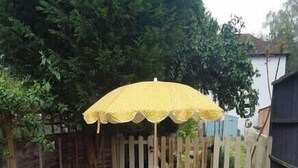 A picnic table with a bench and a yellow umbrella in a backyard. - #07 Edwardian Terrace in Royal Sutton NEC BHX (Birmingham)