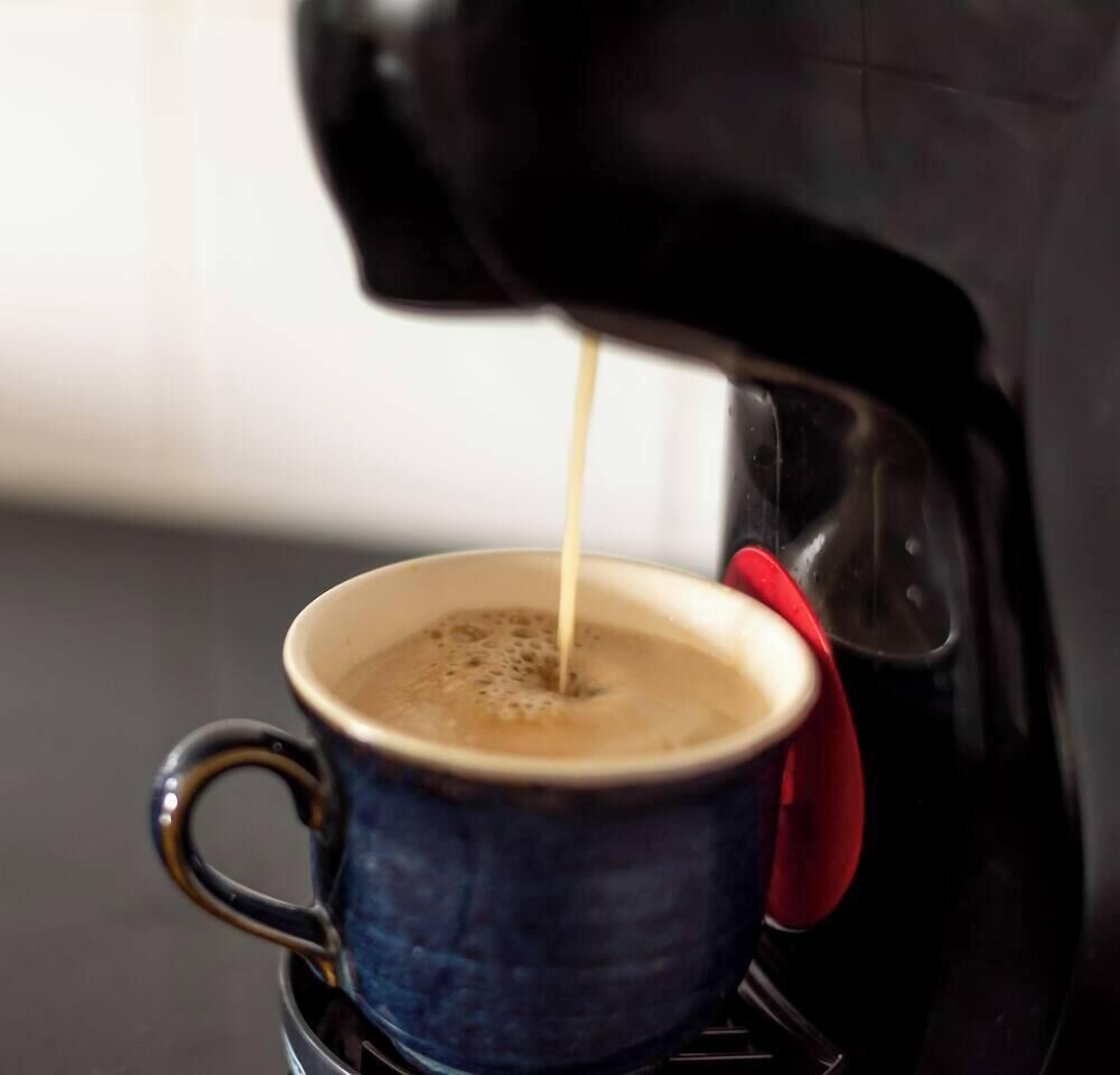 Une machine à café qui verse du café dans une tasse.