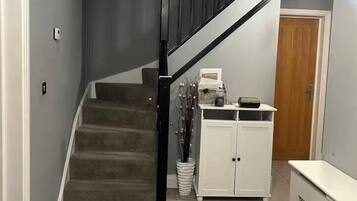 Un escalier avec une rampe noire menant à un palier.