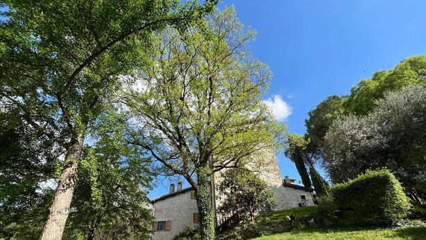 A stone building with a sloped roof, surrounded by lush greenery and trees. - Adagio Umbro rooms B&B Tennis Court (Spoleto)
