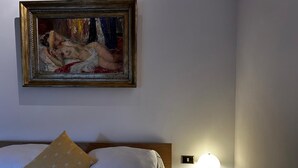 A hotel room with a bed, a painting on the wall, and a bedside lamp. - Adagio Umbro rooms B&B Tennis Court (Spoleto)