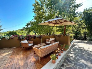 An outdoor patio with wicker furniture, a table, and an umbrella. - Adagio Umbro rooms B&B Tennis Court (Spoleto)