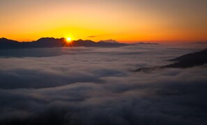 A sunrise over mountains with clouds below. - Stylish Apartment With Mountain Views (Mittersill)