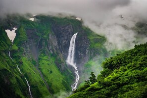 A waterfall surrounded by lush green hills. - Stylish Apartment With Mountain Views (Mittersill)