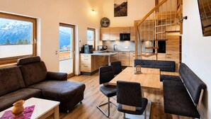 Un intérieur moderne comprenant un coin repas, une cuisine et un escalier.