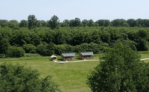 A rural property with two main buildings, a smaller structure, and a well-maintained lawn. - De Glamping - Sunny Trio | 14p (Zeewolde)