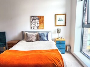 A bedroom with a bed, pillows, a nightstand, a dresser, and a window. - #177 Stylish Finsbury Park Retreat - Sleeps 2 (Greater London)