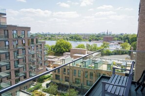 A high-rise building with multiple balconies overlooking a river and cityscape. - #177 Stylish Finsbury Park Retreat - Sleeps 2 (Greater London)