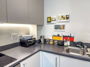 A modern kitchen with a built-in oven, a coffee maker, and a sink. - #177 Stylish Finsbury Park Retreat - Sleeps 2 (Greater London)