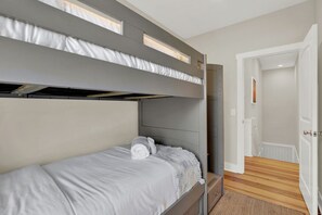 Ein Mehrbettzimmer mit einer Tür zu einem Flur.