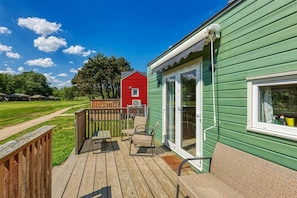 A green building with a deck, a red building in the background, and a clear sky.