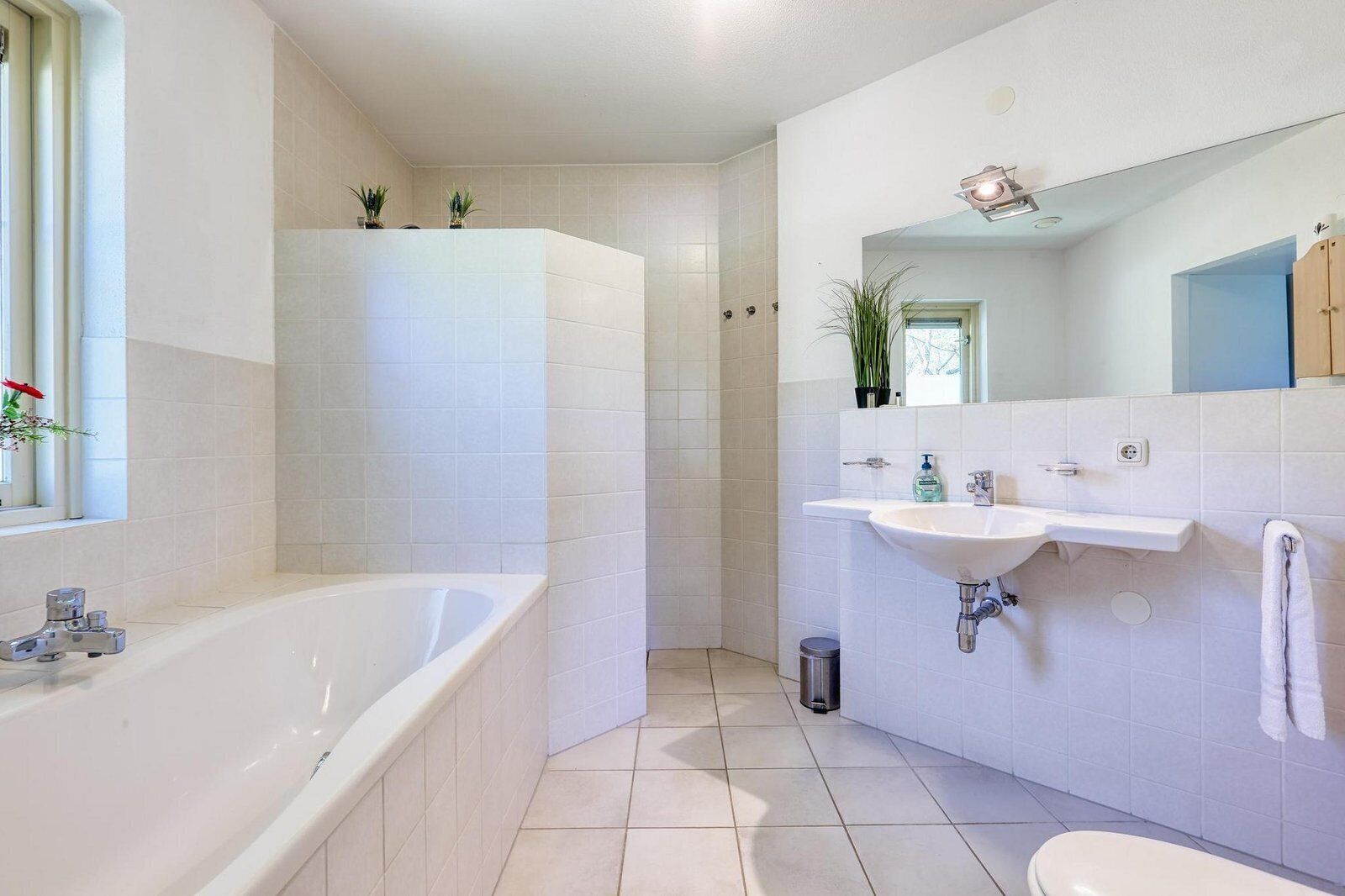 Een moderne badkamer met een bad, een wastafel en een douche.
