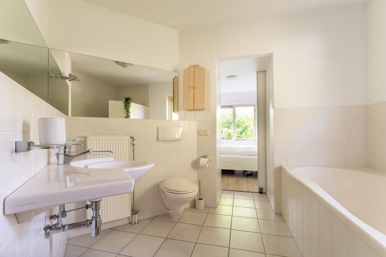 Een moderne badkamer met een bad, toilet en wastafel.