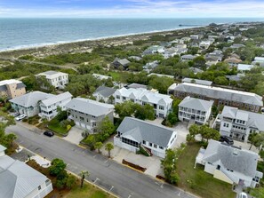 Un quartier résidentiel avec des maisons, une route et une plage en arrière-plan.