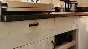 Une cuisine avec des meubles en bois, un four à micro-ondes et une machine à café.