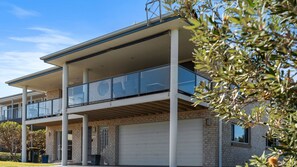Ein zweistöckiges Gebäude mit Garage, großen Fenstern und einem Balkon.