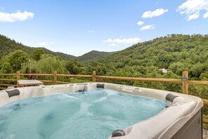 A hot tub with a wooden deck and a view of a mountainous landscape. - Blue Ridge State of Mind | Hot Tub, Fireplace, Dog-Friendly & Biltmore Pass! (Asheville)