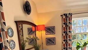 A dining area with a wooden table, white chairs, a red lamp, and wall art. - #05 Fam Apart|sleeps 10|near Kingsbury Water Park (Coleshill)