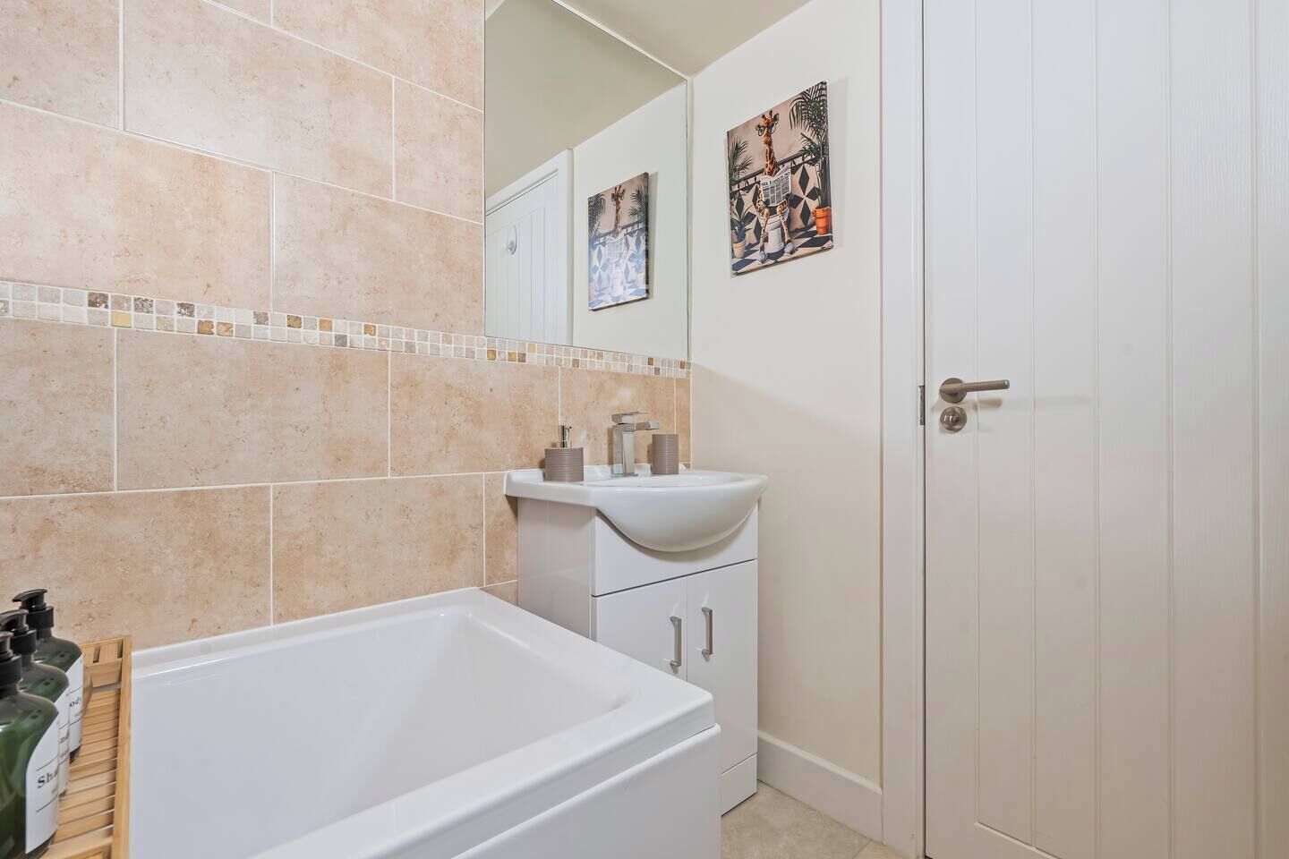 A bathroom with a bathtub, a sink, and a door.