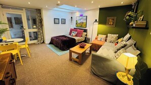 Ein gemütliches Wohnzimmer mit einer Couch, einem Couchtisch und einem Essbereich mit Stühlen.