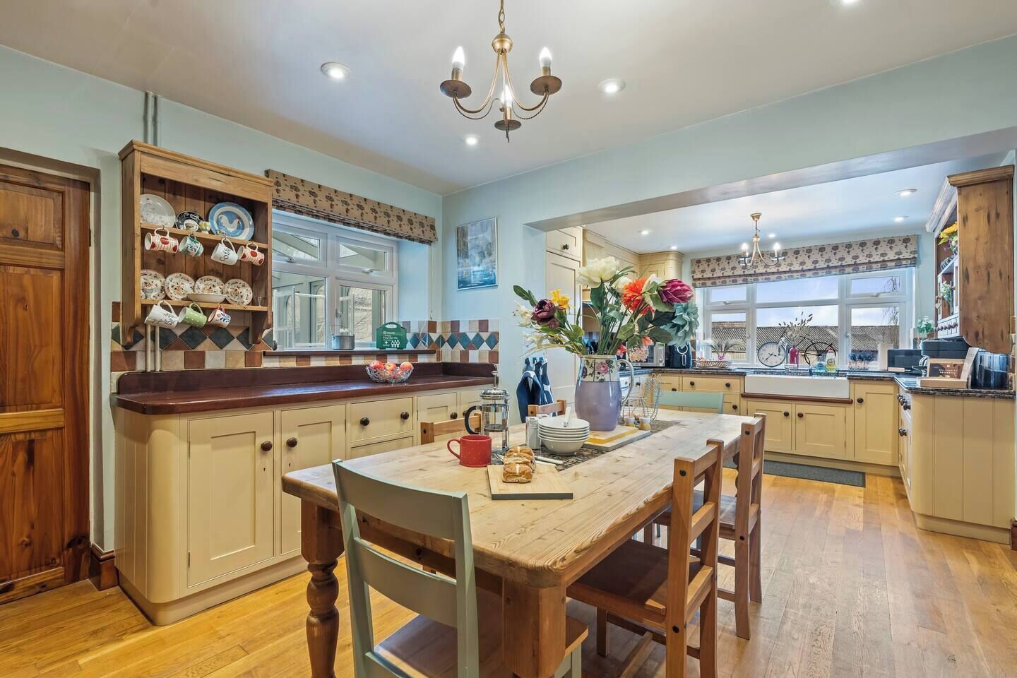 A spacious kitchen with wooden cabinets, a dining table, and a variety of kitchenware.
