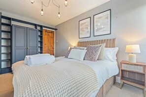 A bedroom with a bed, bedside tables, a wardrobe, and a ceiling light fixture. - #110 Charming Country Stay at Brook Farm, Somerset (Whatley)