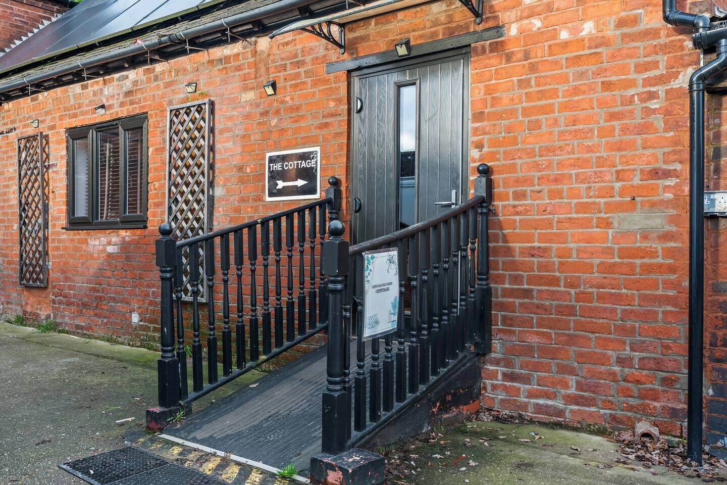 A brick building with a sign reading 'The Cottage.'