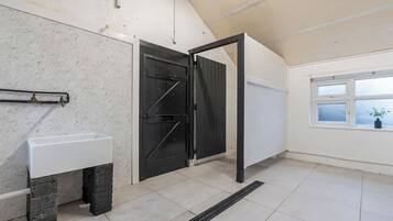 A room with a white sink, a black door, and a window with a view.