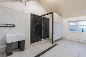 A room with a white sink, a black door, and a window with a view.