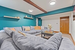 A modern living room with a sectional sofa, a coffee table, and teal accent walls.