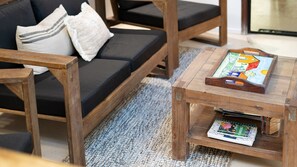 A wooden coffee table with a calendar and a crossword puzzle book.