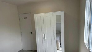 Un dormitorio con cama, armario y puerta.