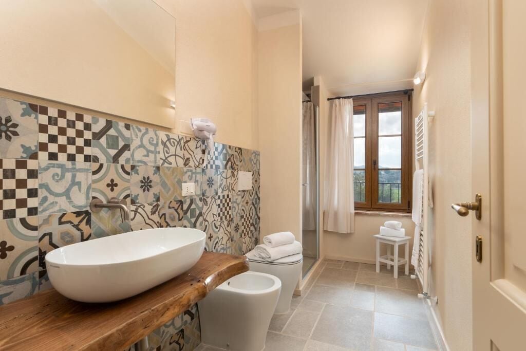 Ein Badezimmer mit einem großzügigen Waschtisch, einer Toilette und einer Duschkabine.