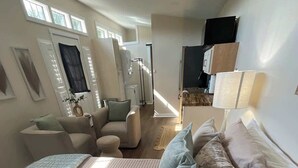 Una camera da letto con un letto, due sedie, una scrivania e una televisione.