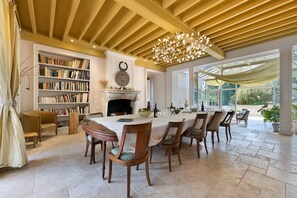 A dining area with a large table, chairs, and a fireplace. - Holiday Home 'Grande Villa Italienne Avec Parc' with Private Pool, Private Terrace and Wi-Fi (Saint-Étienne-de-Mer-Morte)