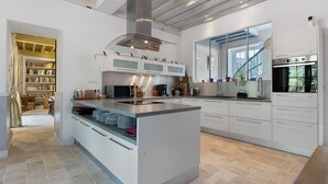 A modern kitchen with a central island, built-in appliances, and a view of the outdoors.