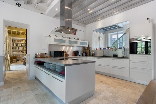 A modern kitchen with a central island, built-in appliances, and a view of the outdoors.