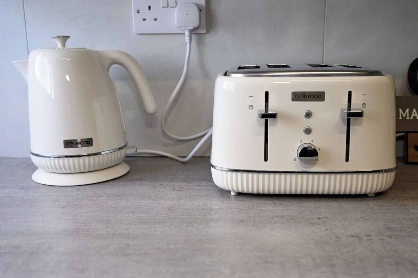 A kitchen with a white kettle and a white toaster on a countertop.